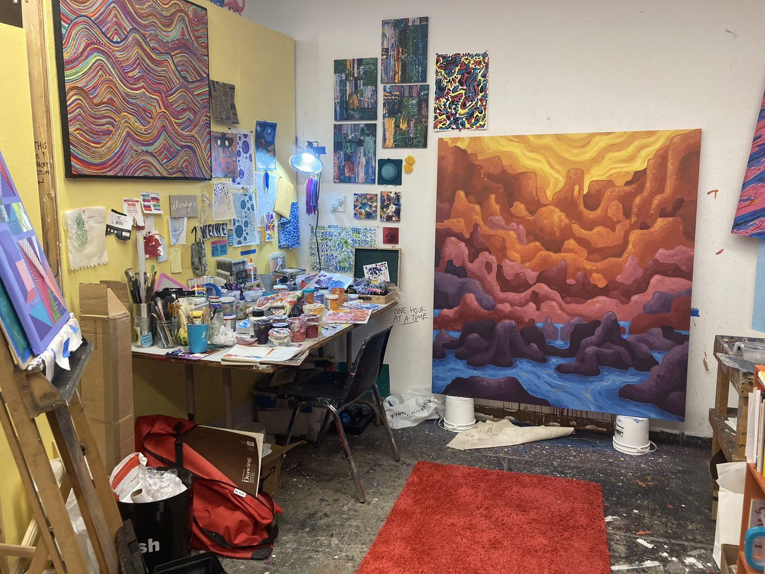 Ray A. Laventure's studio with the large canyon painting New England Man Yearns for Canyons on the wall and a paint-spattered worktable.